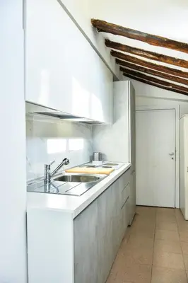 a kitchen with white cabinets and a sink at Appartamento Piazza del parlamento 3 in Rome