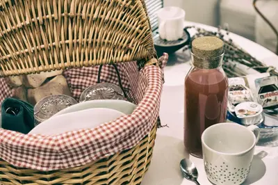a basket of dishes and a bottle of syrup on a table at Santa Nara B&B in Rome