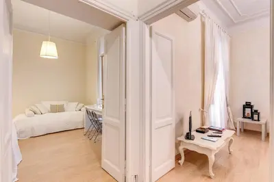 a white room with a bed and a table at RHH Rome Holiday Home in Rome