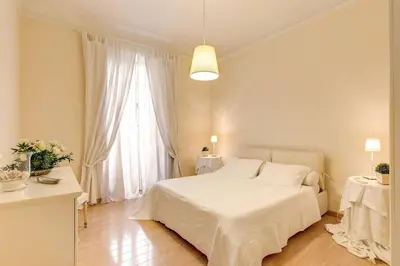 a white bedroom with a white bed and a window at RHH Rome Holiday Home in Rome