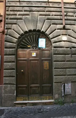 a large wooden door in a stone building at STELLA'S APARTMENT IN MONTI in Rome