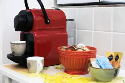 a red coffee maker and a basket of eggs on a counter at STELLA'S APARTMENT IN MONTI in Rome