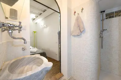 a bathroom with a stone sink and a shower at STELLA'S APARTMENT IN MONTI in Rome