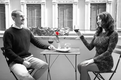 a man and woman sitting at a table with wine glasses at Vatican Relais Rome Suite in Rome