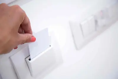 a hand holding a piece of paper on a lightswitch at Relais Dolcevita in Rome