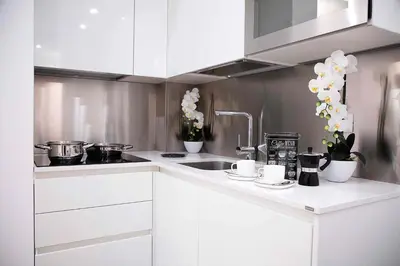 a kitchen with white cabinets and a sink at Relais Dolcevita in Rome