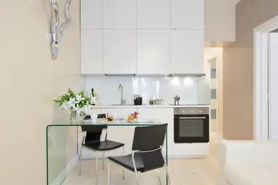 a kitchen with a glass table and black chairs at Petra Apartments in Rome