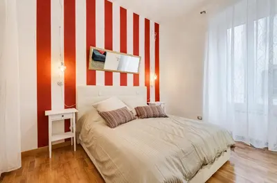 a bedroom with a bed with red and white stripes at San Cosimato House in Rome