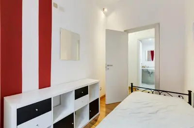 a bedroom with a bed and a red and white wall at San Cosimato House in Rome