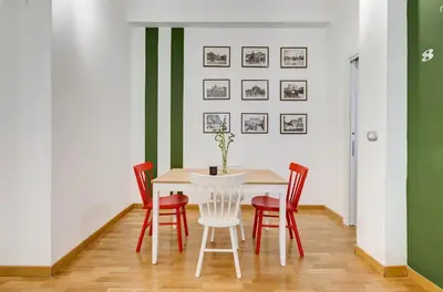 a dining room with a white table and red chairs at San Cosimato House in Rome