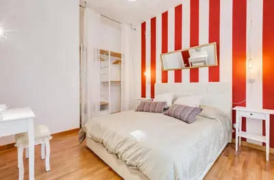 a bedroom with a white bed with red and white stripes at San Cosimato House in Rome
