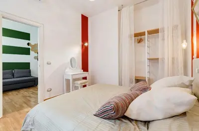 a bedroom with a large white bed with pillows at San Cosimato House in Rome