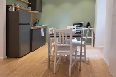 a kitchen with a table with two chairs and a refrigerator at Flaminio New Apartment in Rome