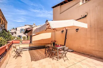 a table and chairs with an umbrella on a patio at Appartamenti - Via del Monte della Farina in Rome
