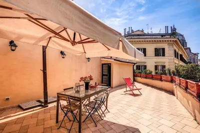 a patio with a table and a large umbrella at Appartamenti - Via del Monte della Farina in Rome