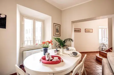 a dining room with a white table and chairs at Appartamenti - Via del Monte della Farina in Rome