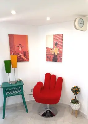 a red chair in a room with a table at La casetta di Josephine in Rome