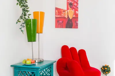 two red chairs sitting next to a table with a vase at La casetta di Josephine in Rome