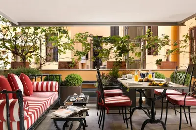 a patio with a couch and a table and chairs at Hotel De' Ricci - Small Luxury Hotels of the World in Rome