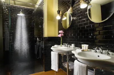 a bathroom with two sinks and a shower at Hotel De' Ricci - Small Luxury Hotels of the World in Rome