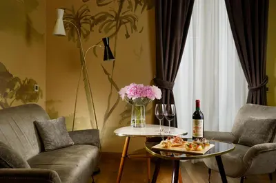 a living room with a table with a vase of flowers at Hotel De' Ricci - Small Luxury Hotels of the World in Rome
