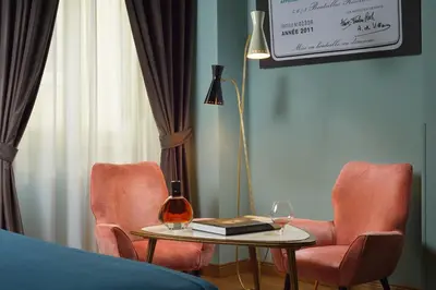 a living room with two chairs and a table and a lamp at Hotel De' Ricci - Small Luxury Hotels of the World in Rome