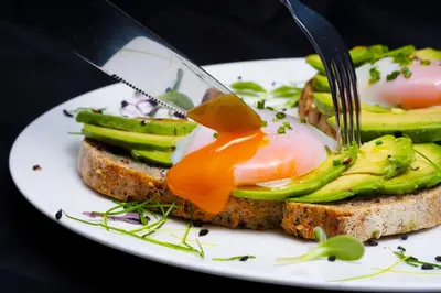 a plate of food with a egg on a sandwich at Hotel De' Ricci - Small Luxury Hotels of the World in Rome