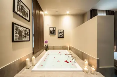 a bath tub in a bathroom with candles and flowers at BeSecret Vittoriano - Vittoriano Luxury Suites in Rome