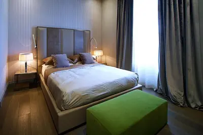 a bedroom with a large bed and a green ottoman at BeSecret Vittoriano - Vittoriano Luxury Suites in Rome