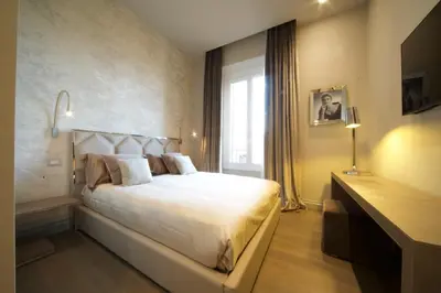a bedroom with a large white bed and a window at BeSecret Vittoriano - Vittoriano Luxury Suites in Rome