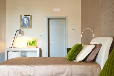 a bedroom with a bed with green and white pillows at BeSecret Vittoriano - Vittoriano Luxury Suites in Rome