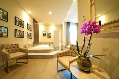 a bathroom with a vase with purple flowers on a table at BeSecret Vittoriano - Vittoriano Luxury Suites in Rome