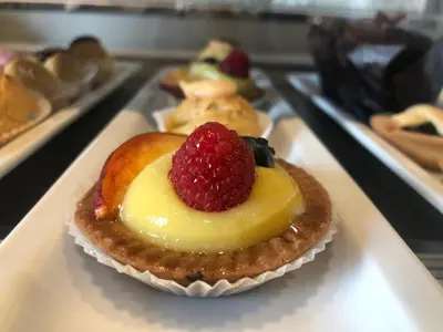 a cupcake with a raspberry on it on a tray at BeSecret Vittoriano - Vittoriano Luxury Suites in Rome