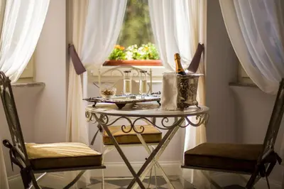 a table and two chairs in a room with a window at Trastevere Royal Suite in Rome