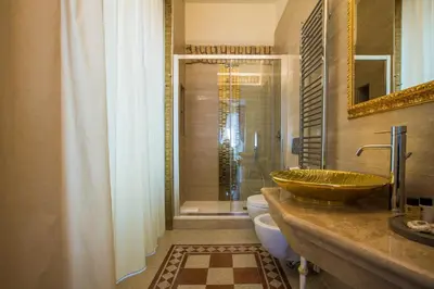 a bathroom with a sink and a toilet and a shower at Trastevere Royal Suite in Rome