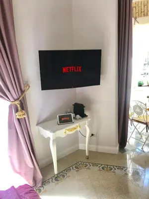 a white table with a television on a wall at Trastevere Royal Suite in Rome