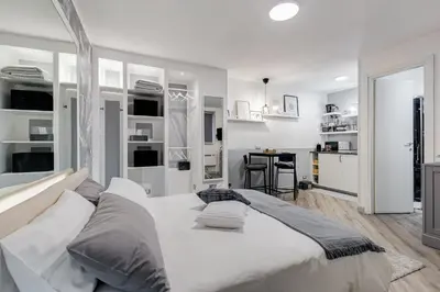 a white bedroom with a large bed with pillows at Diecipassi dal Colosseo in Rome