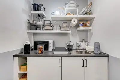 a kitchen with white cabinets and a sink at Diecipassi dal Colosseo in Rome