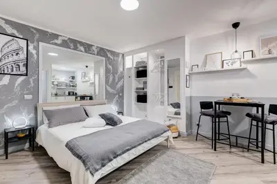 a bedroom with a bed and a desk in it at Diecipassi dal Colosseo in Rome