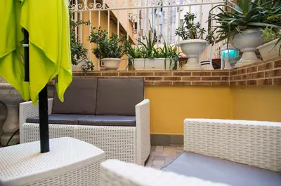a patio with a table and chairs and plants at Fabiola's Home in Rome