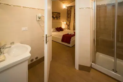 a bathroom with a sink and a shower and a bed at Fabiola's Home in Rome