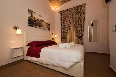 a bedroom with a large white bed with red pillows at Fabiola's Home in Rome