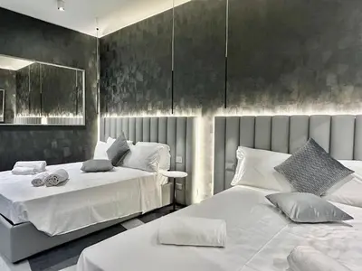 a bedroom with two beds with white sheets at Private Luxury Suites in Rome