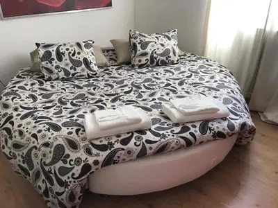 a bed with a black and white blanket and pillows at Attico incantevole, Pìgneto Roma in Rome