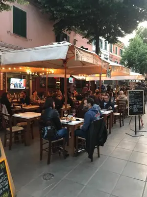 a group of people sitting at tables in a restaurant at Attico incantevole, Pìgneto Roma in Rome