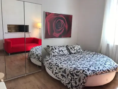 a bedroom with a bed and a red couch at Attico incantevole, Pìgneto Roma in Rome
