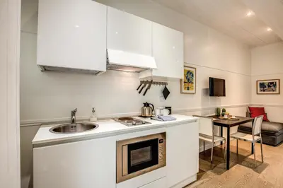 a kitchen with a sink and a table in a room at Colosseo Suite Apartment in Rome