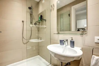 a bathroom with a sink and a shower at Colosseo Suite Apartment in Rome