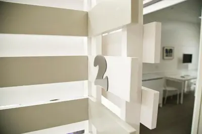 a room with white cabinets with a table in the background at Colosseo Suite Apartment in Rome