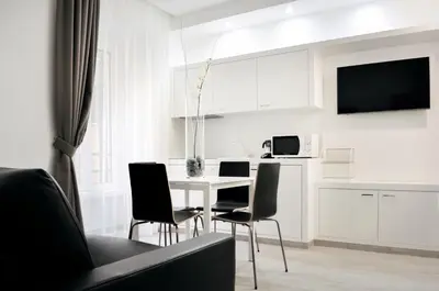 a kitchen and dining room with a table and chairs at LHP Suite Roma Termini in Rome